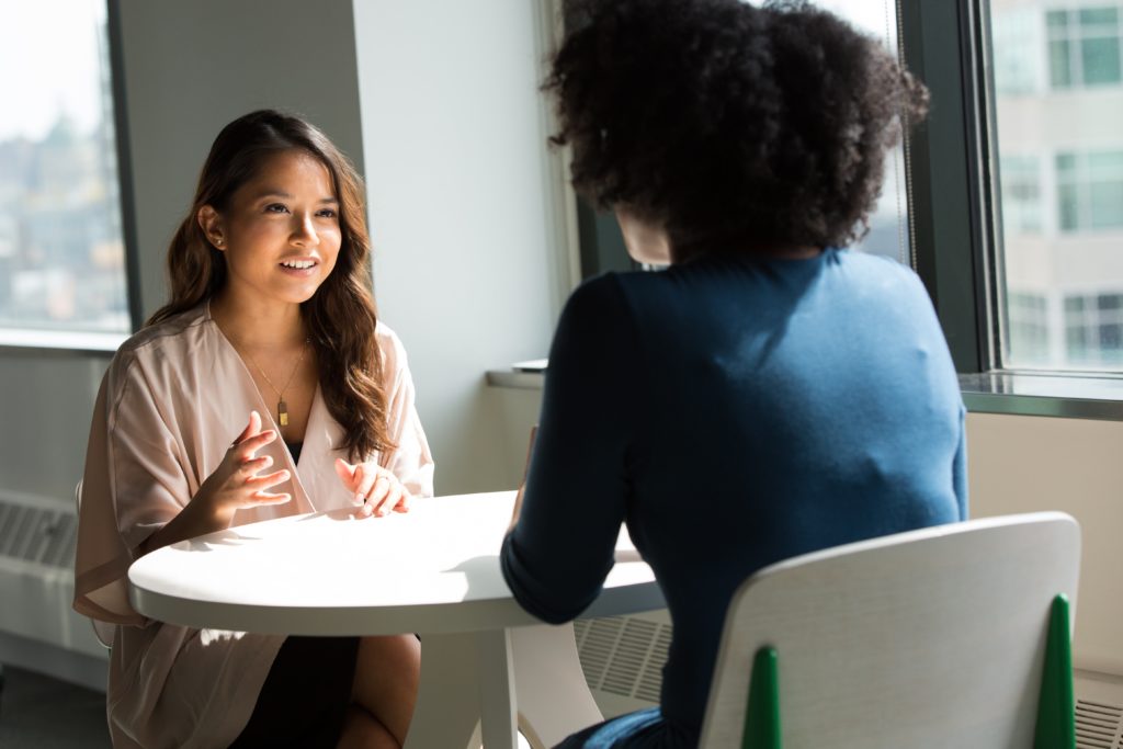 coaching services, two business women talking in office setting